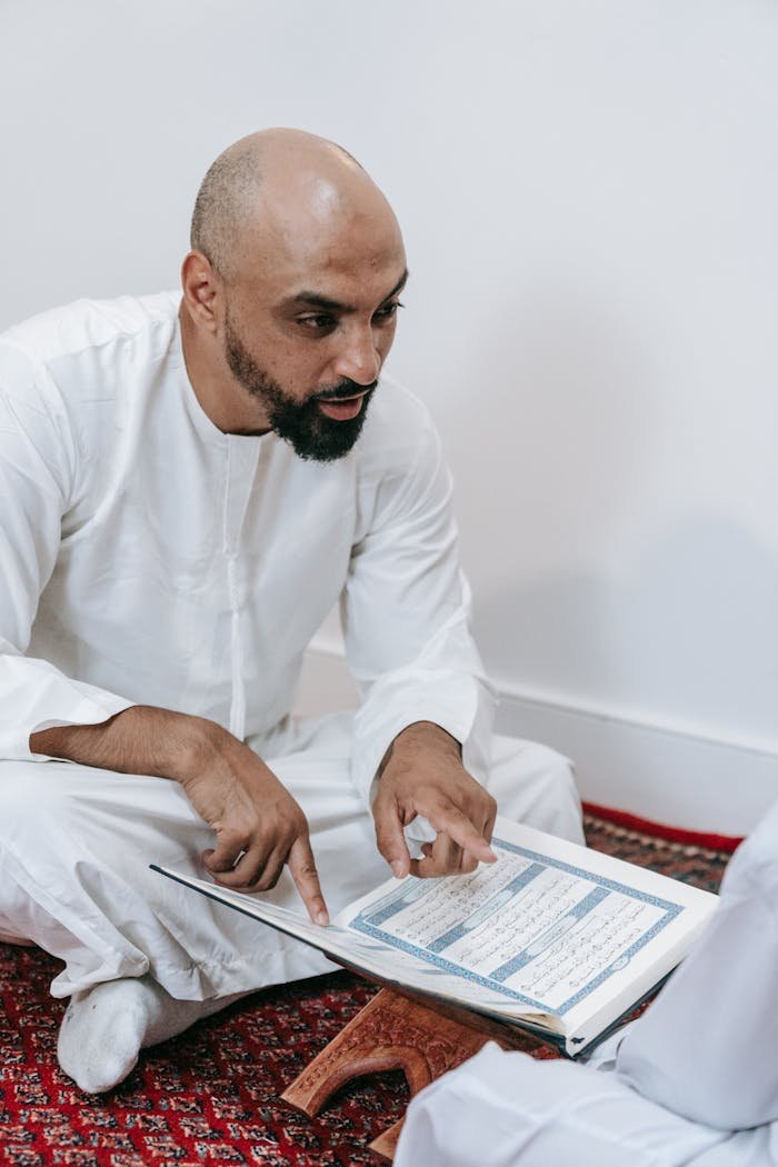 Man in White Thobe Sitting on the Ground